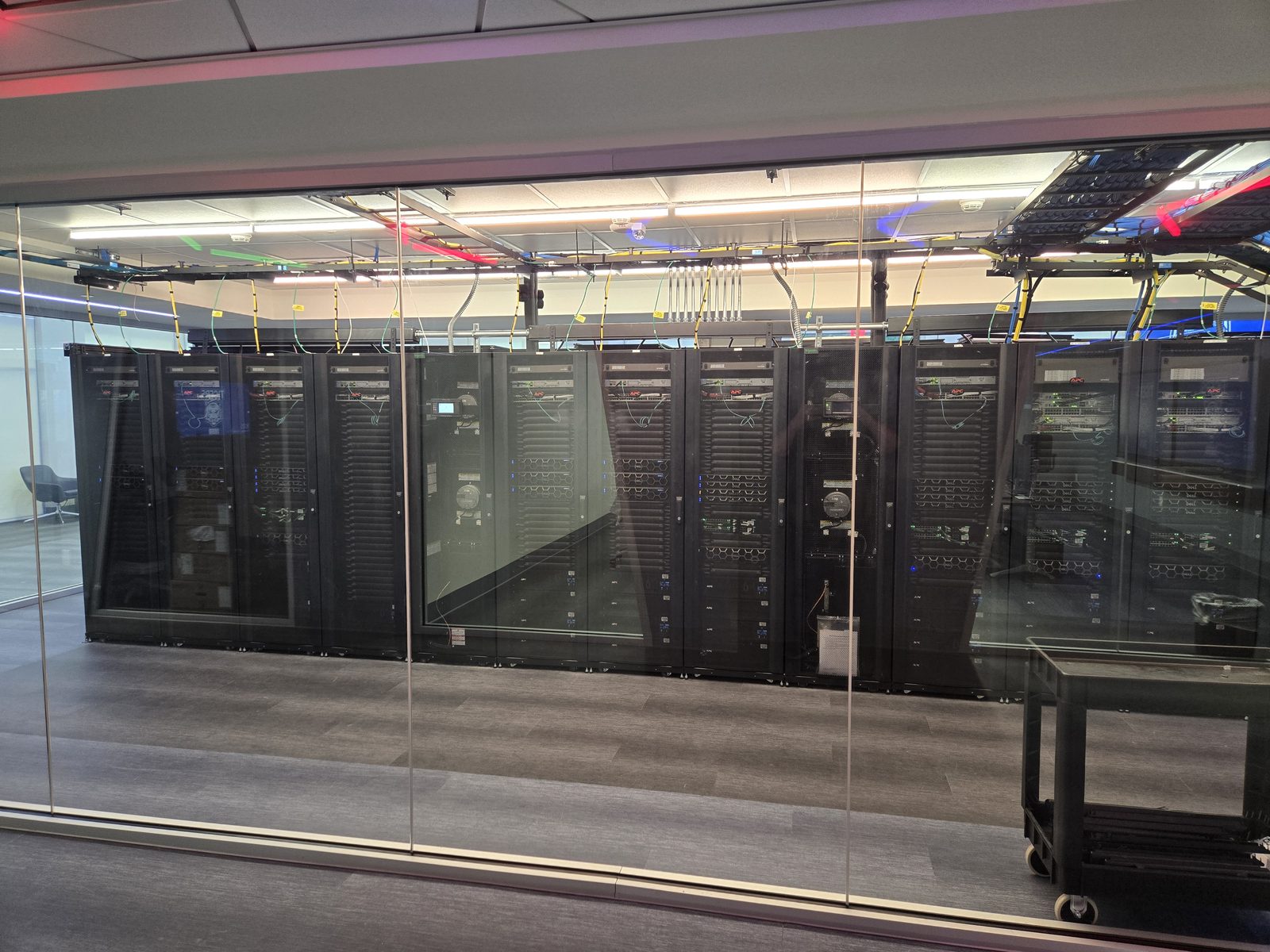 RedKnight data center — racks of servers and network equipment behind a glass wall