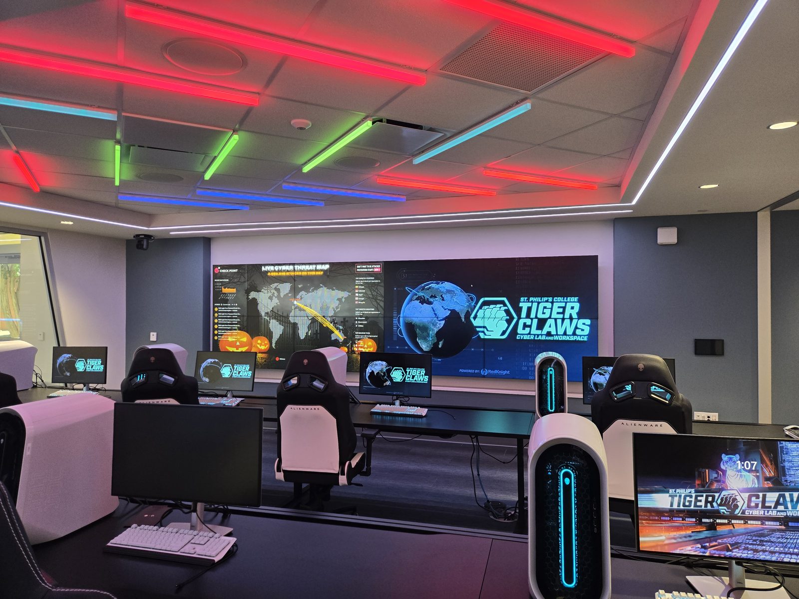 Tiger Claws Cyber Lab and Workspace — rows of workstations facing a video wall with a live cyber threat map